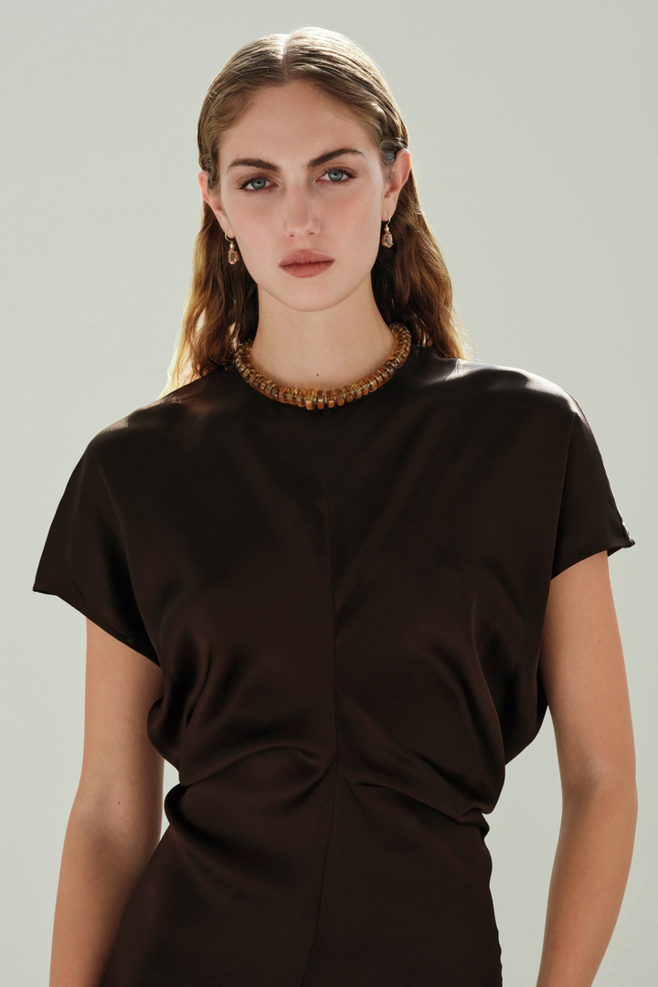 Ileana Makri pear-cut morganite and diamond drop earrings in 14K yellow gold worn by a model in a brown silk top.