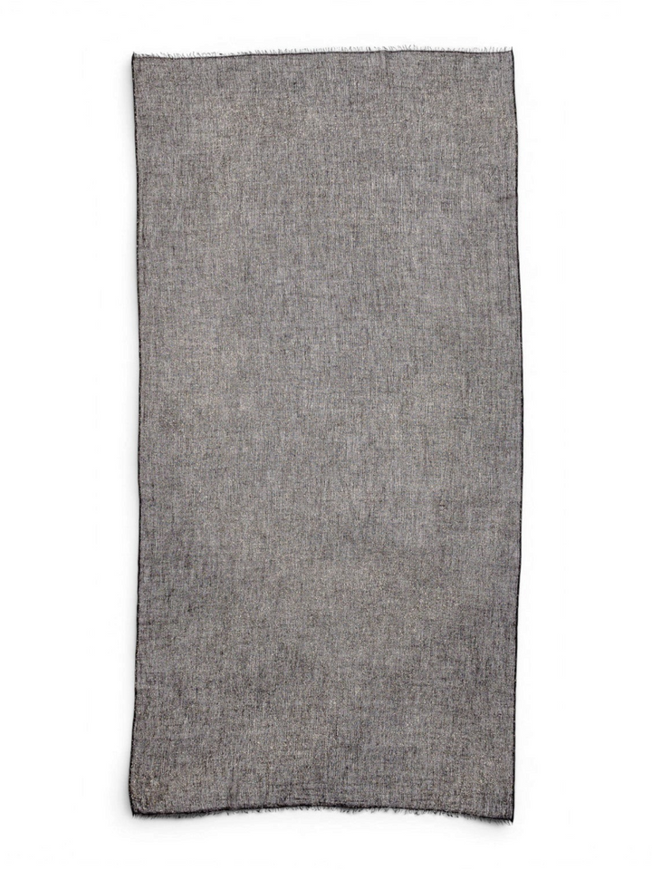 Ileana Makri Tamarindo black cashmere scarf with a delicate shimmer and frayed edges, flat lay view.