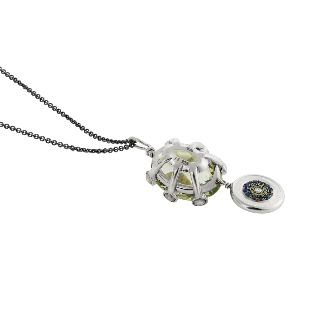 Ileana Makri double eye pendant featuring a green amethyst, green diamonds, and sapphires on a dark steel chain.