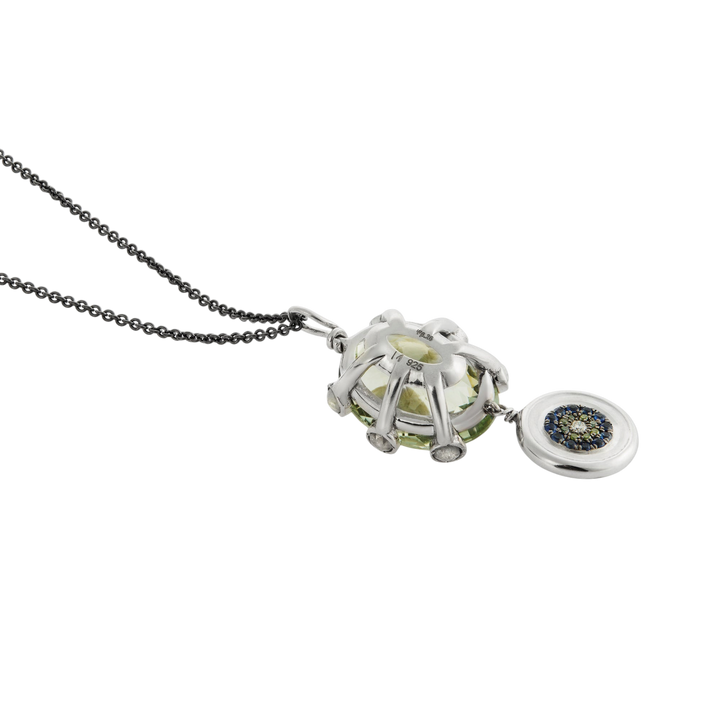 Ileana Makri double eye pendant featuring a green amethyst, green diamonds, and sapphires on a dark steel chain.