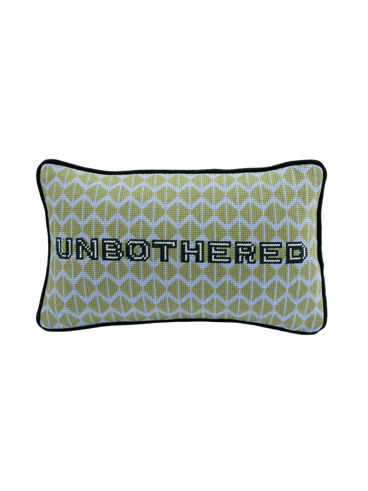 Ileana Makri Unbothered needlepoint pillow featuring a green geometric pattern and black embroidered text.
