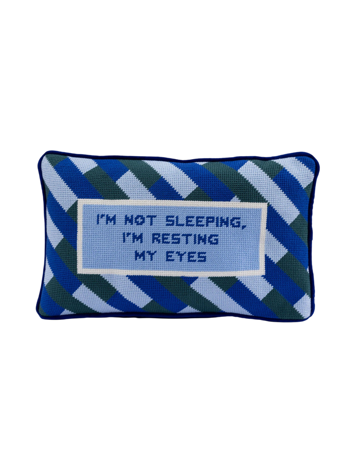 Ileana Makri needlepoint pillow featuring a blue geometric pattern and the text I'm not sleeping, I'm resting my eyes.