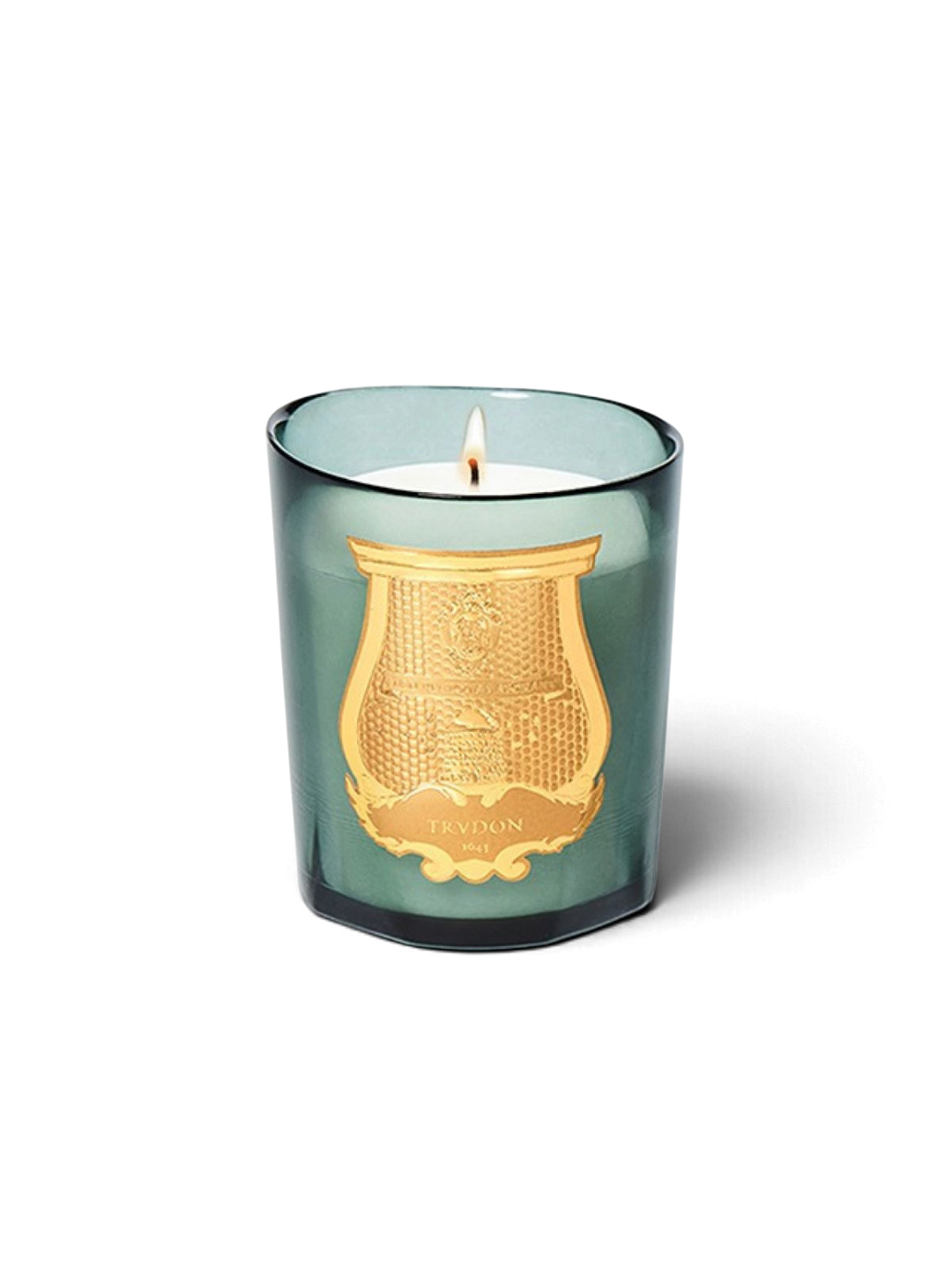 Ileana Makri Cire Trudon Figuerie candle in a green glass vessel with a gold emblem, emitting a warm fig fragrance.