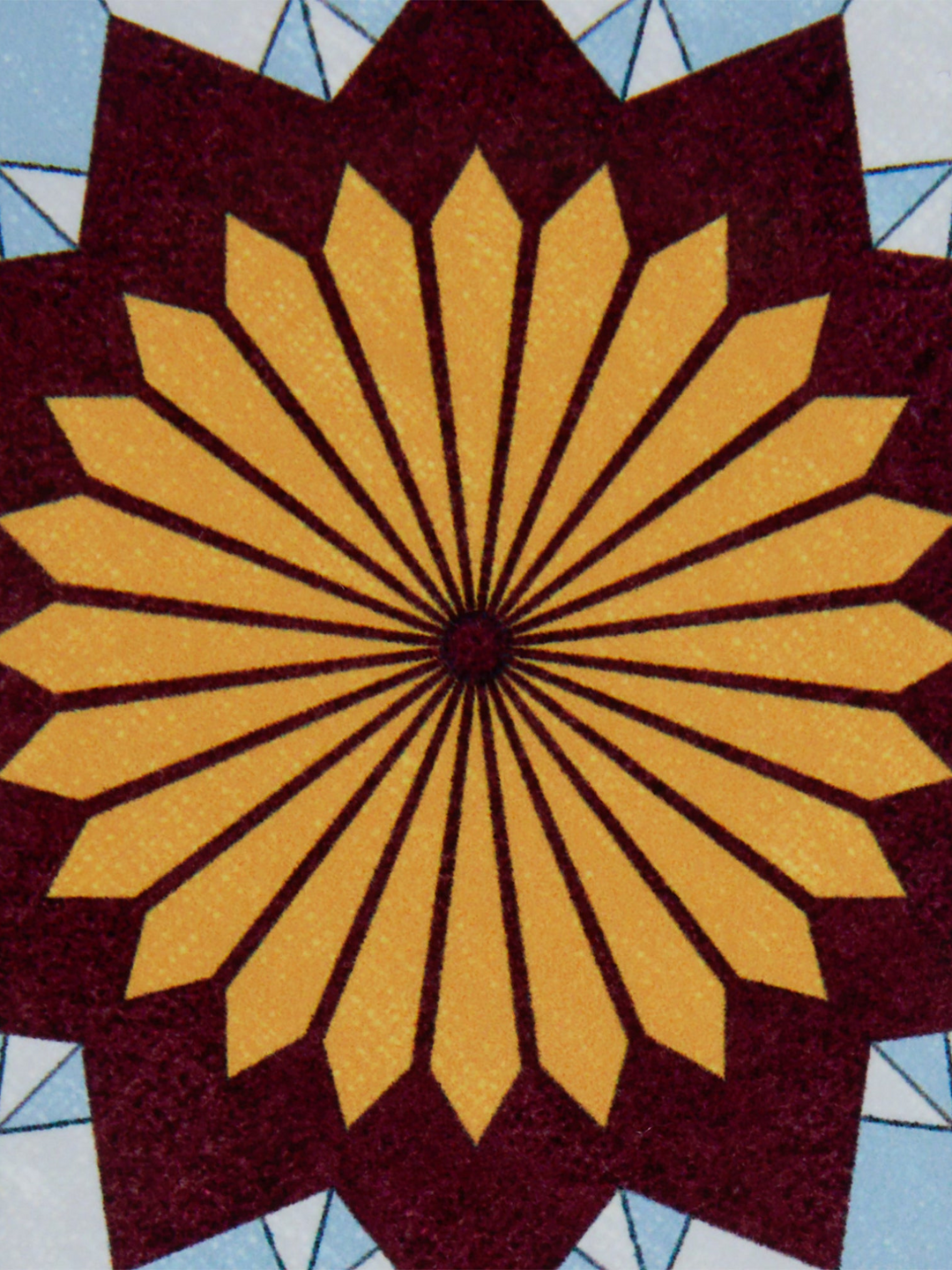 Ileana Makri Lotus of Life circular coaster featuring a vibrant geometric sunburst pattern in gold, maroon, and blue.