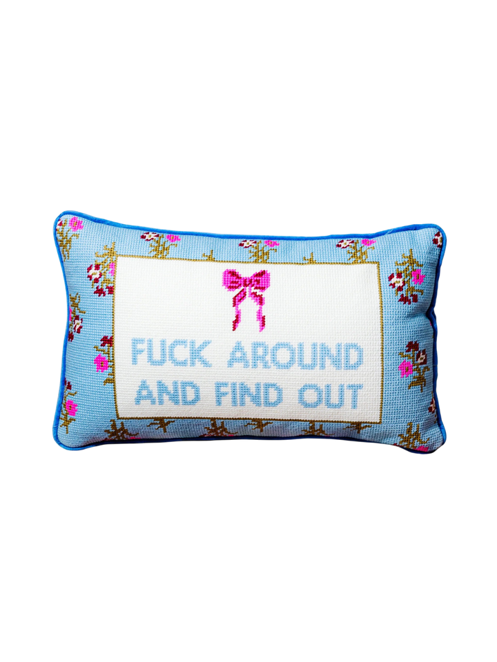 Ileana Makri needlepoint pillow with blue floral pattern, pink bow, and the phrase F*** Around And Find Out.