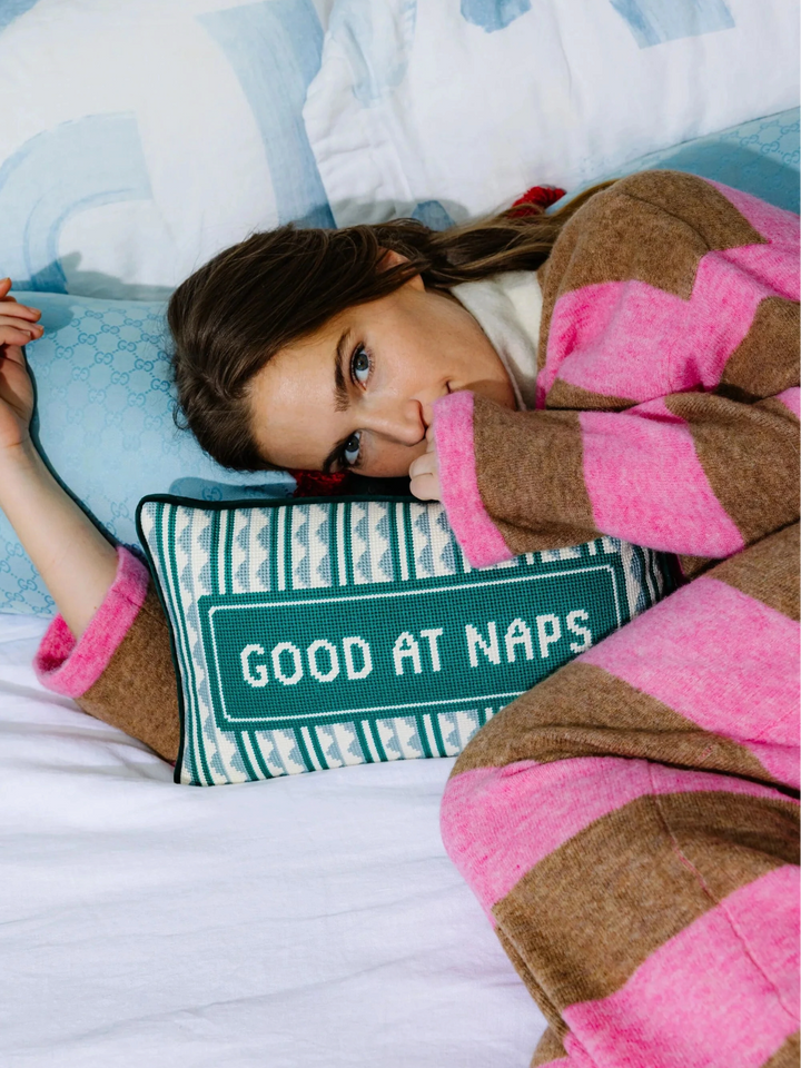 Ileana Makri Good at Naps needlepoint pillow with green and white geometric pattern resting on a bed