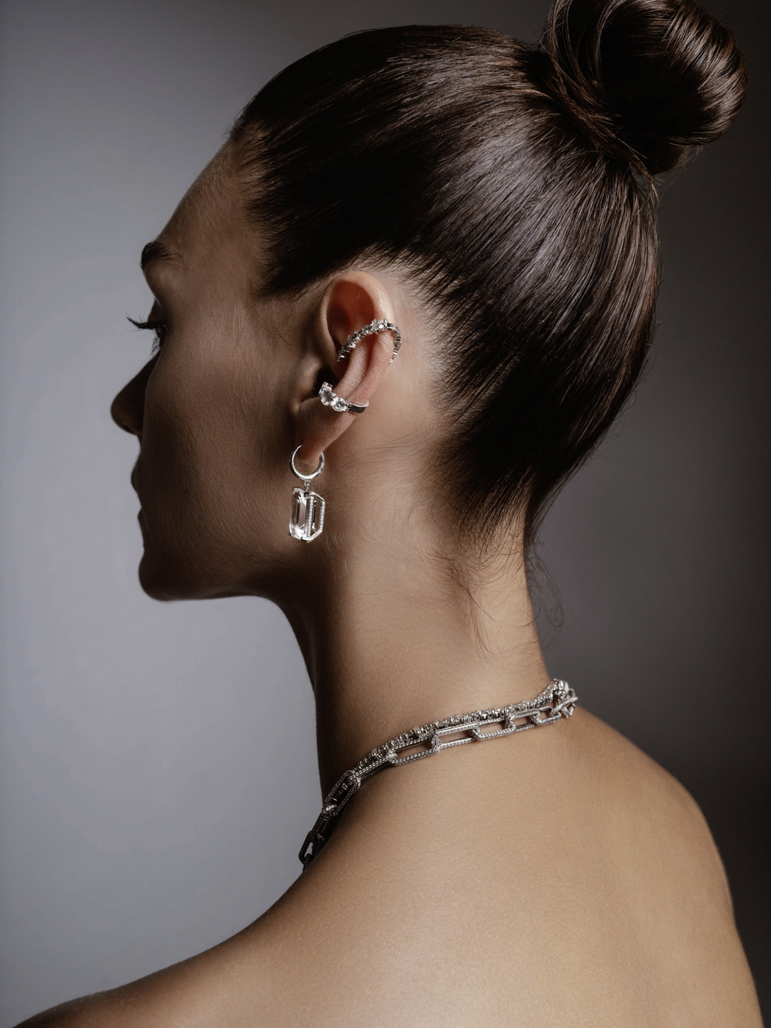 Ileana Makri Royal Crown white gold hoops with white topaz and diamond accents worn by a model in profile view