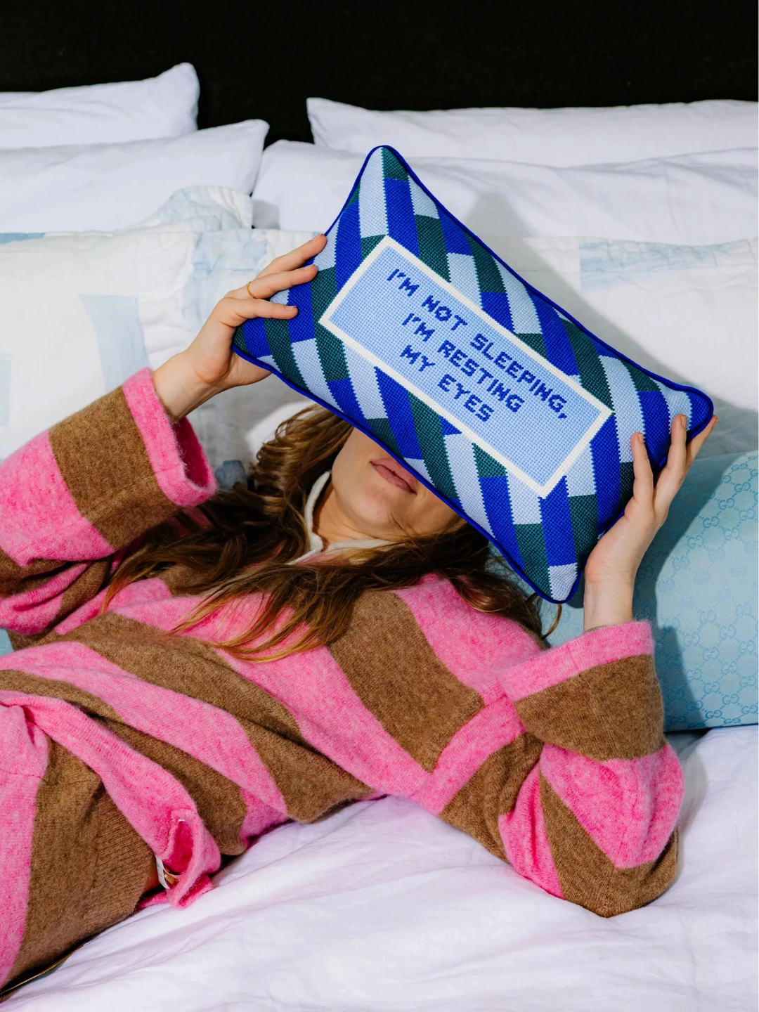 Ileana Makri needlepoint pillow with blue and green stripes and the phrase I'm not sleeping I'm resting my eyes