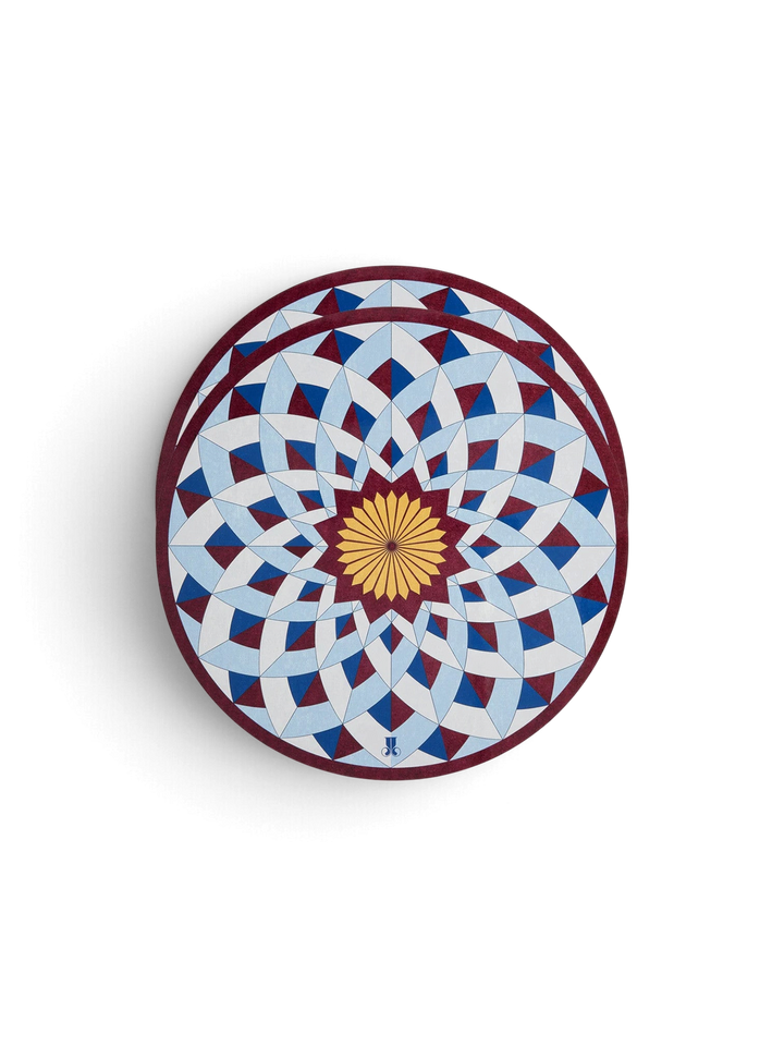 Ileana Makri Lotus of Life circular placemats featuring a blue and geometric mosaic pattern with a cork backing.