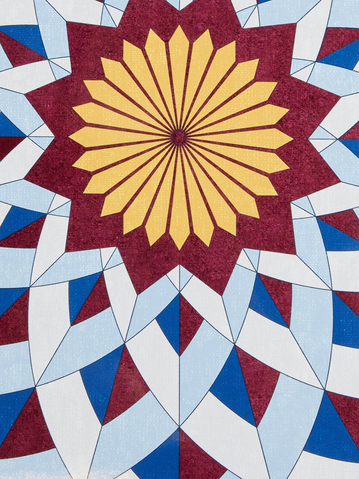 Ileana Makri Lotus of Life circular placemat featuring a geometric blue, burgundy, and yellow mosaic-inspired pattern.