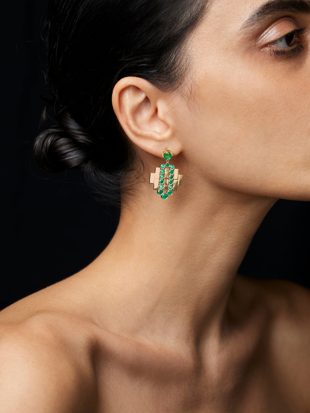 Ileana Makri Emerald Flow Bridge earrings in 18k yellow gold with vivid green emeralds worn on a model