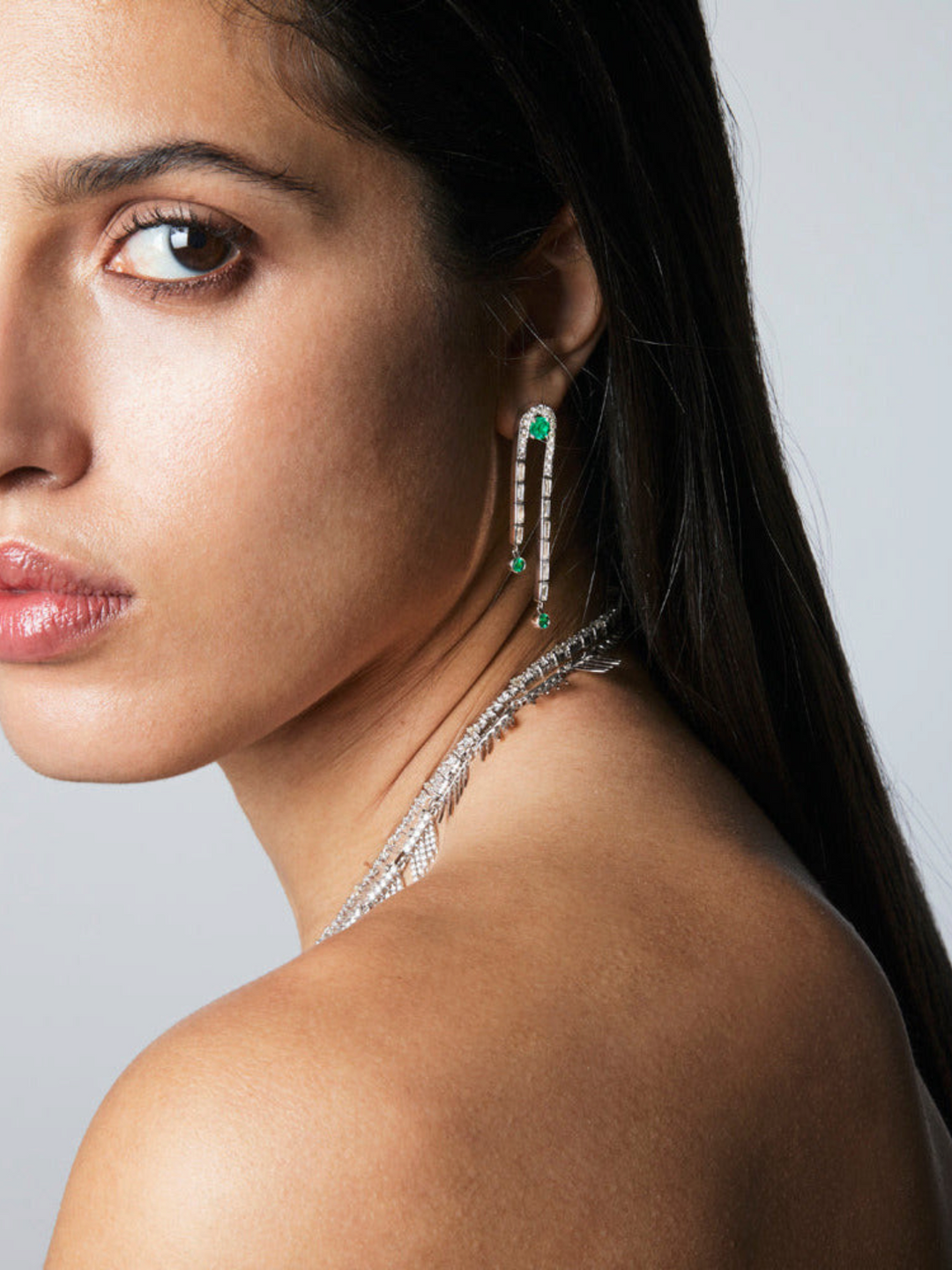 Ileana Makri Frozen Stream earrings in 18k white gold with emeralds and baguette diamonds worn by a model