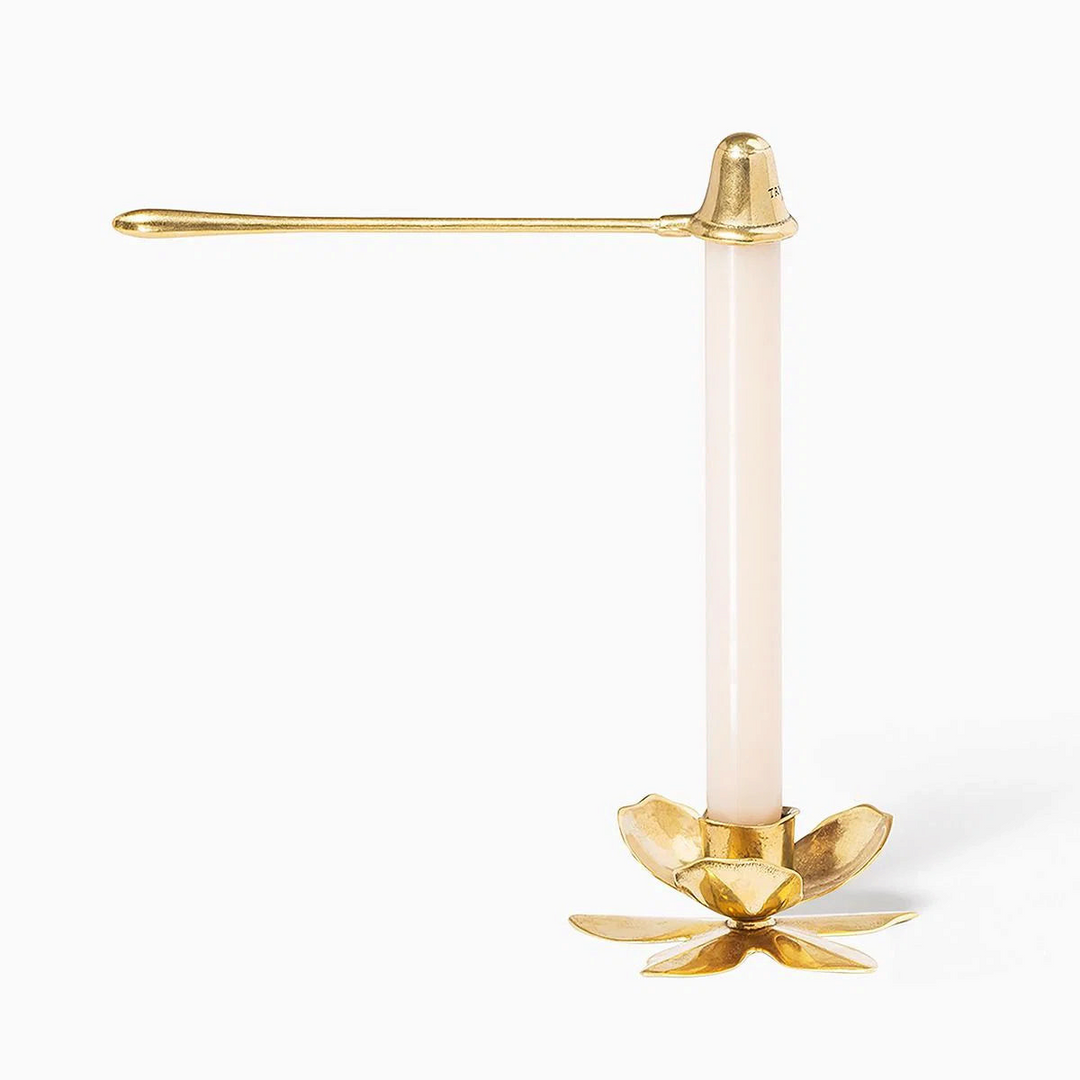 Ileana Makri gold taper candle snuffer with a floral base and white candle, showcasing elegant handcrafted design.