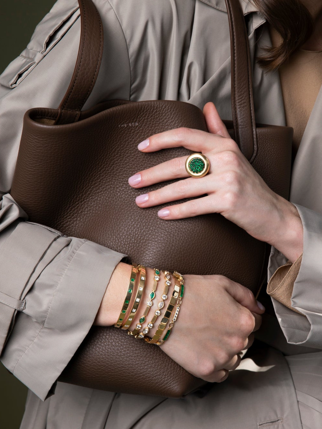 Ileana Makri Emerald Navette Stream Bracelet in 18k yellow gold with diamonds, worn on a wrist with a brown leather bag