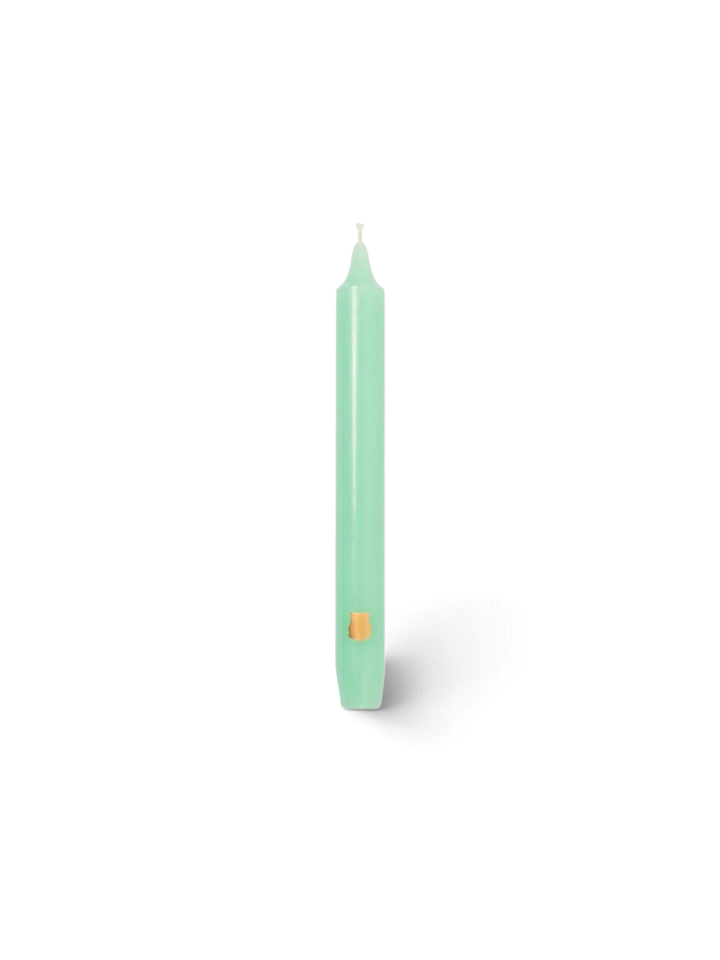 Ileana Makri watery green Madeleine tapered candle with a small gold emblem detail on a white background