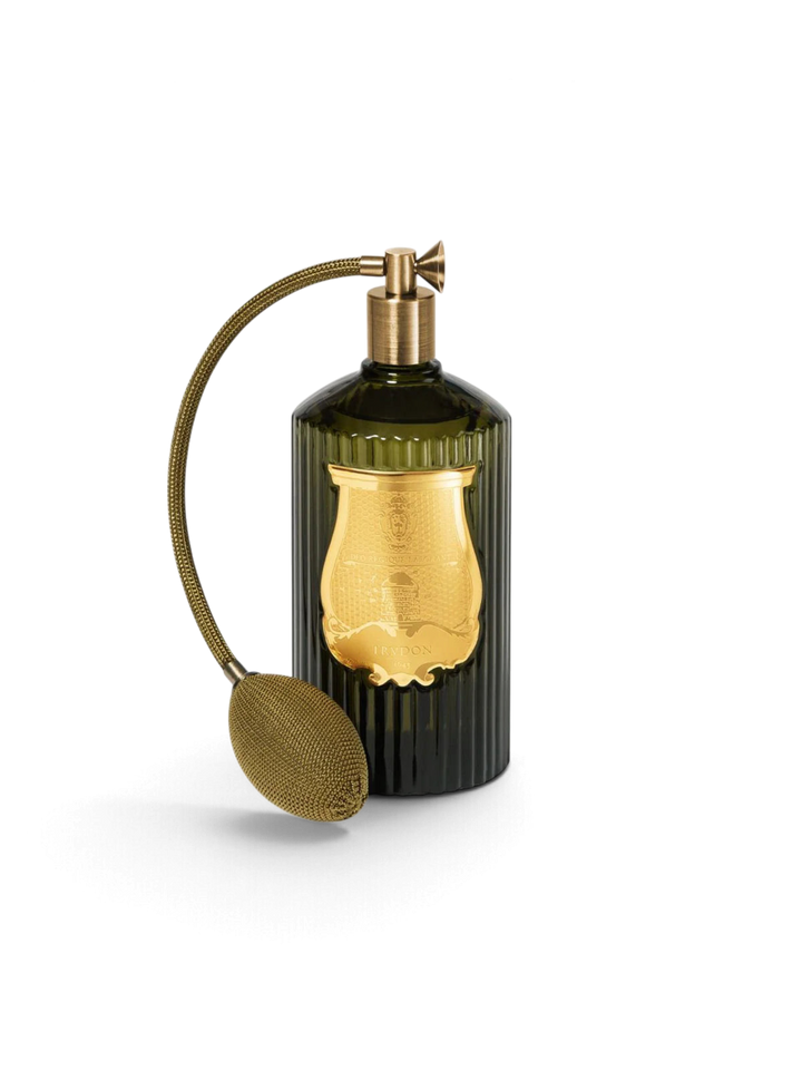 Ileana Makri Cire Trudon Abd El Kader room spray in a dark green ribbed glass bottle with a gold atomizer bulb.