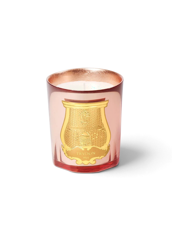 Ileana Makri Trudon Nazareth scented candle in a rose-tinted glass vessel with a gold embossed emblem