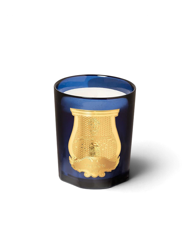 Ileana Makri Trudon Ourika scented candle in a deep blue glass vessel with a gold embossed emblem