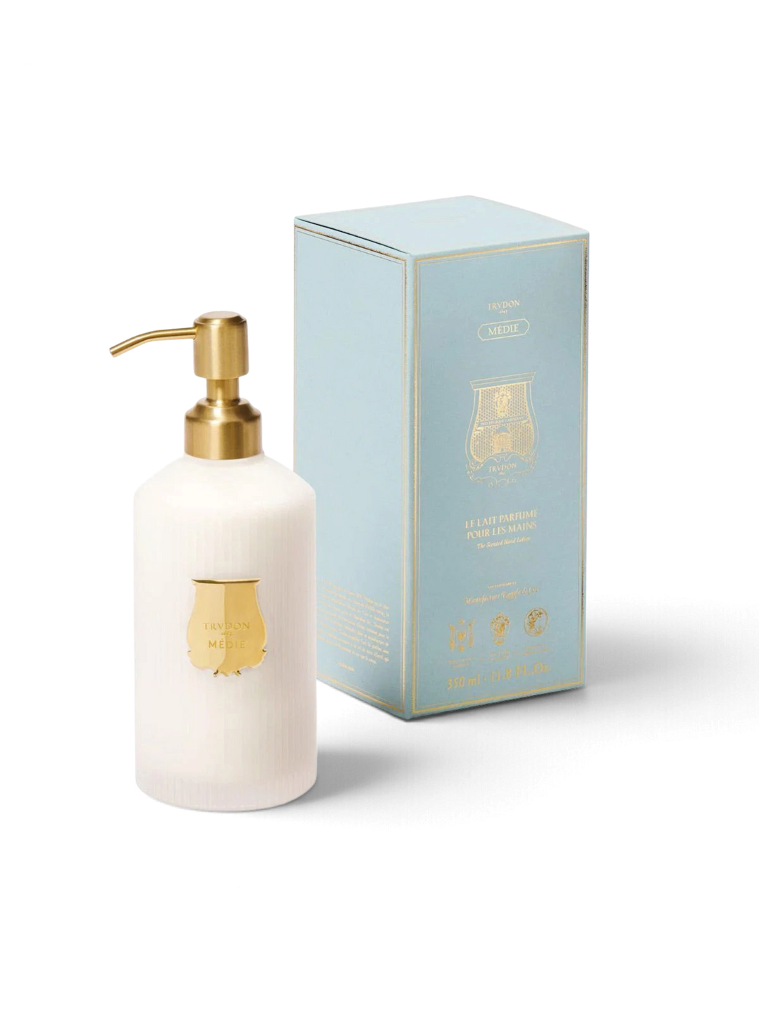 Ileana Makri Trudon Médie scented hand lotion in a white ribbed bottle with a gold pump and matching light blue box.
