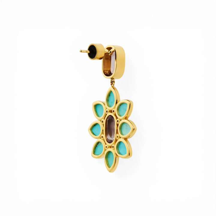Gold drop earring with turquoise and central oval gemstone in floral design on white background