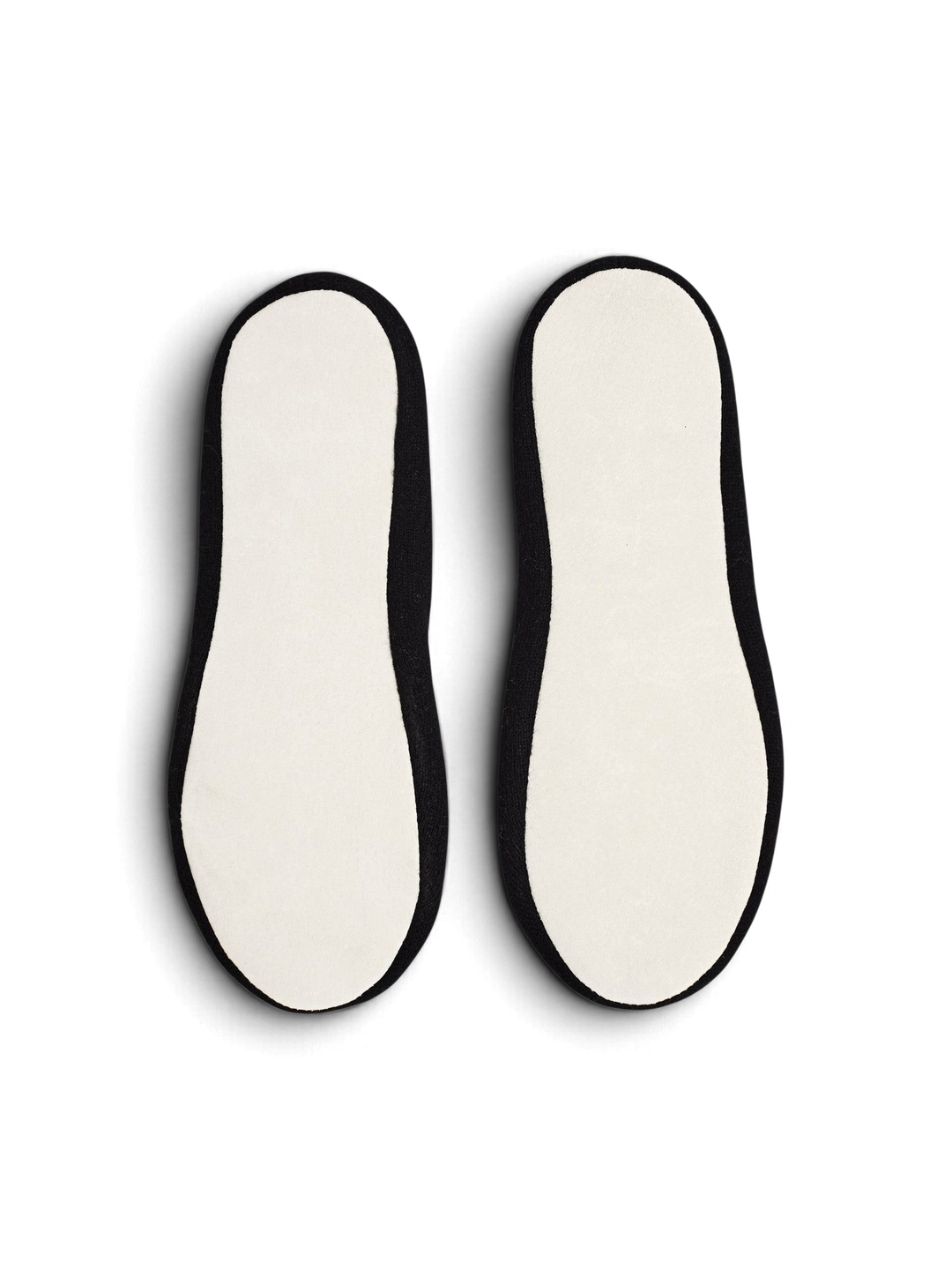 Ileana Makri Dolly slippers featuring black cashmere uppers and white suede soles, viewed from the bottom.