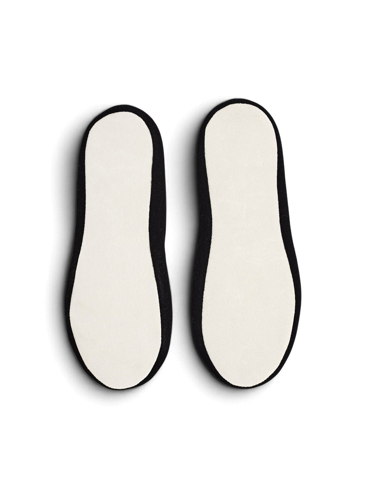 Ileana Makri Dolly slippers featuring black cashmere uppers and white suede soles, viewed from the bottom.